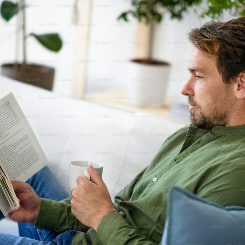 ソファでくつろぎ読書する男性